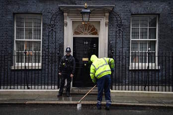 Un operario barre a las puertas del 10 de Downing Street. 