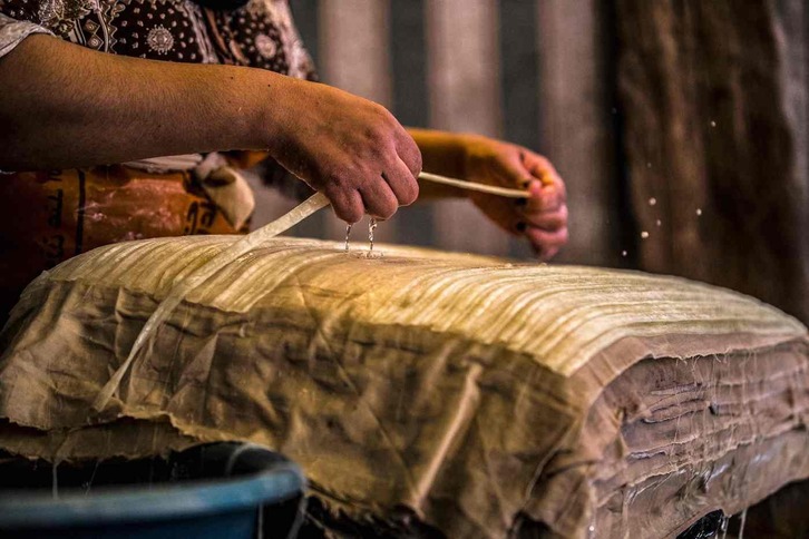 Una mujer prepara papiro para comprimirlo y secarlo en el taller del pueblo de al-Qaramous, en la fértil región norteña del delta del Nilo en Egipto.