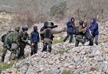 Fuerzas israelíes tratan de evitar que colonos se acerquen a palestinos en la zona de Burin, cerca de Nablus, en la Cisjordania ocupada. 