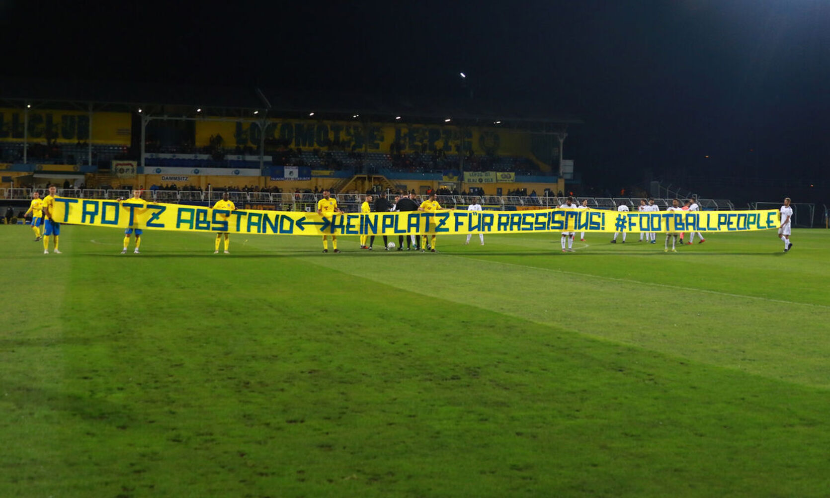 Los jugadores del Lokomotive Leipzig portan una pancarta antes de un partido.