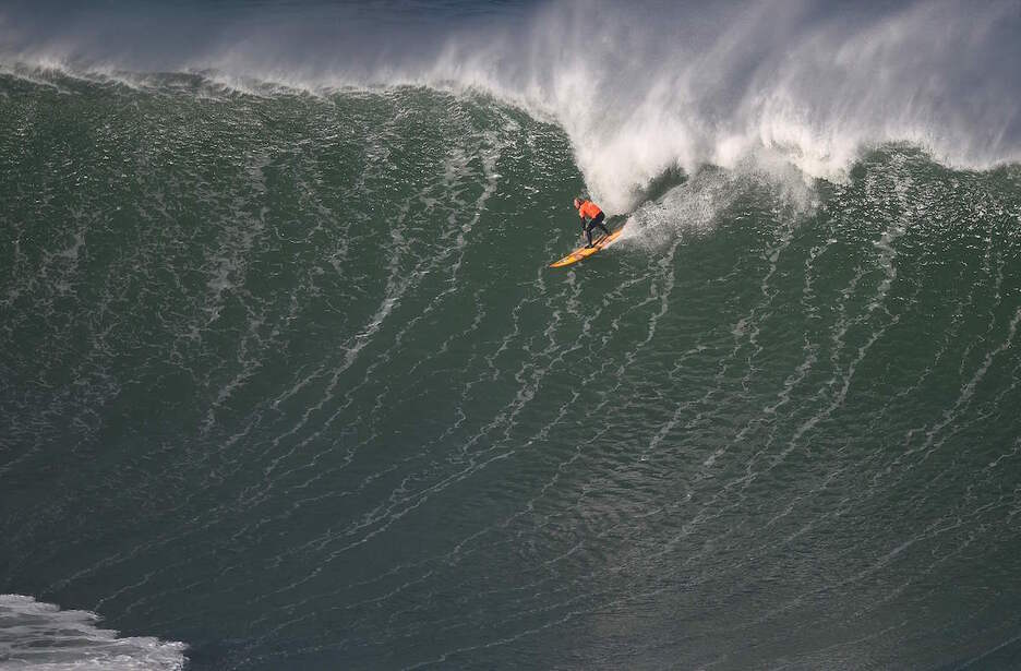 Surflari bat, olatu handi bat hartzeko prest.