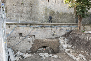 Un ciclista sube por la cuesta de Santo Domingo junto a las obras en las que aparece el puente durmiente.