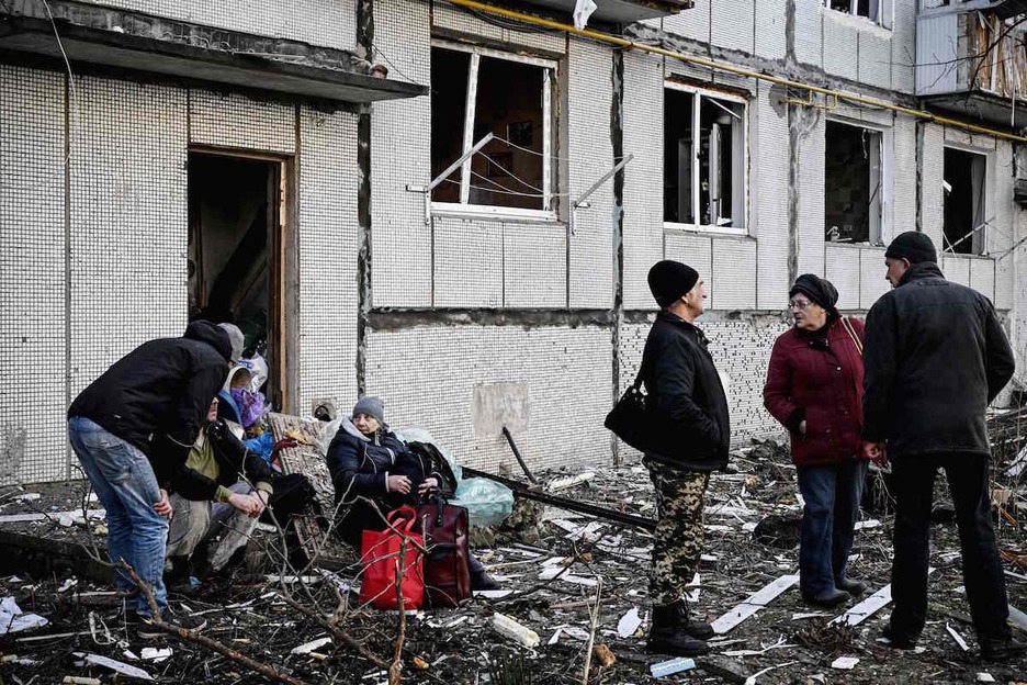 Vecinos de Chuguyev, junto a un edificio afectado por la ofensiva rusa.