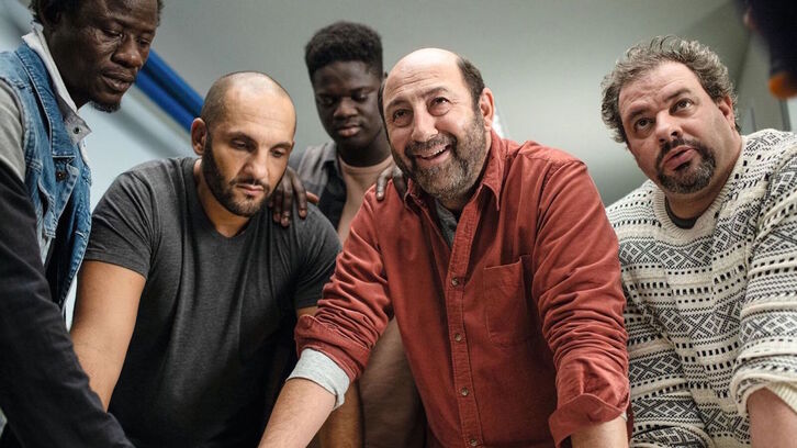 Kad Meran rodeado por su grupo de teatro, compuesto por reclusos.