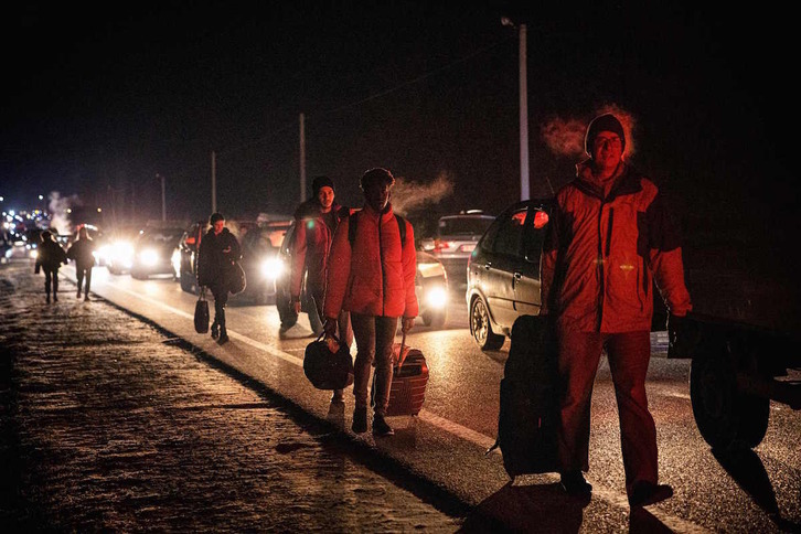 Personas se dirigen a pie o en coche hacia la frontera entre Ucrania y Polonia.