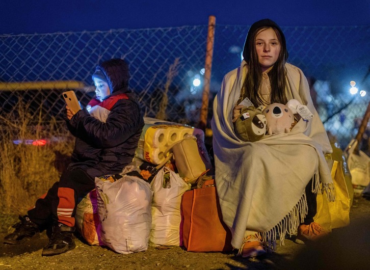 Dos menores de Ucrania descansan tras haber cruzado la frontera con Polonia. 