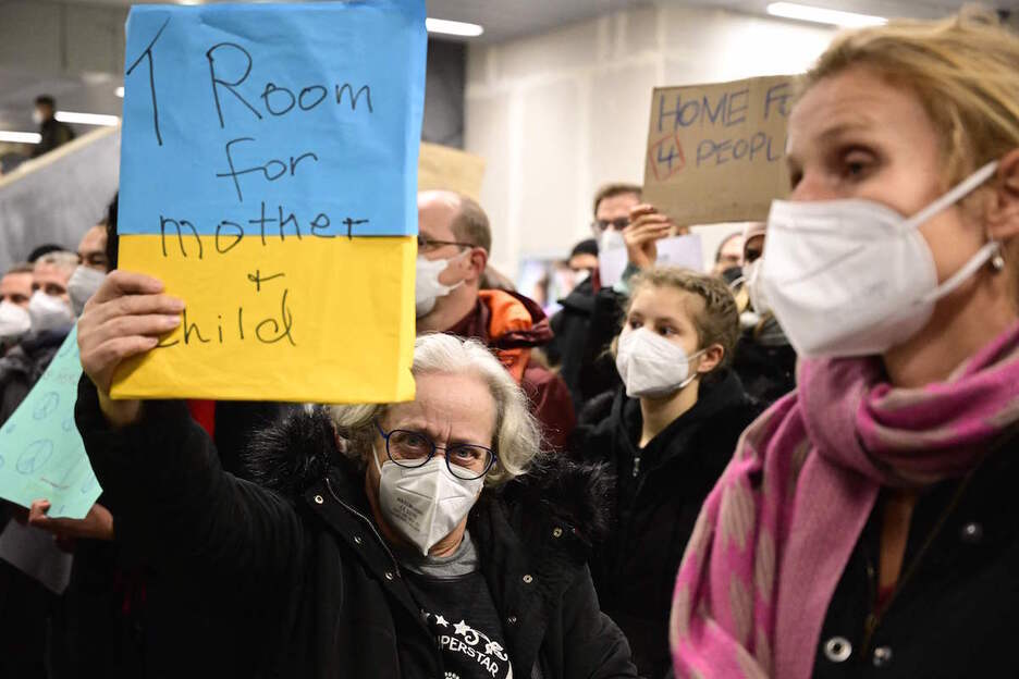 Una mujer ofrece una habitación para una madre y su hijo en la estación de Berlin.