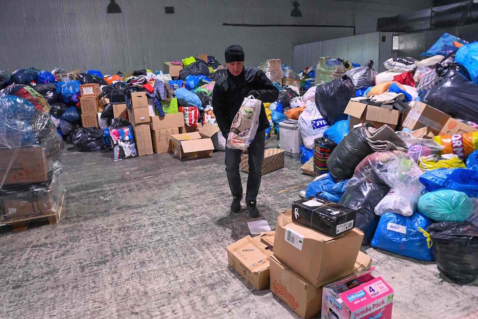 Un voluntario local clasifica la ayuda en una base de recolección de alimentos, medicinas y ropa en el pueblo de Solomonovo, ciudad ucraniana cerca de Eslovaquia.