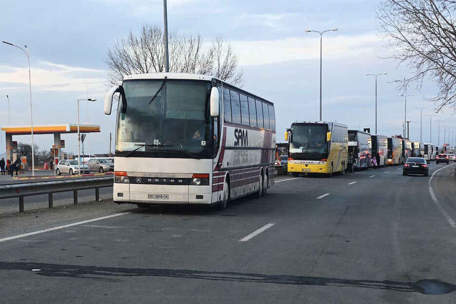 Varios autobuses esperan para cruzar la frontera entre Ucrania y Hungria.