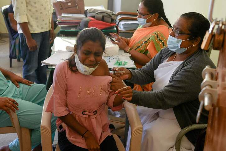 Una trabajadora sanitaria vacuna a una mujer en Bangalore, India. 
