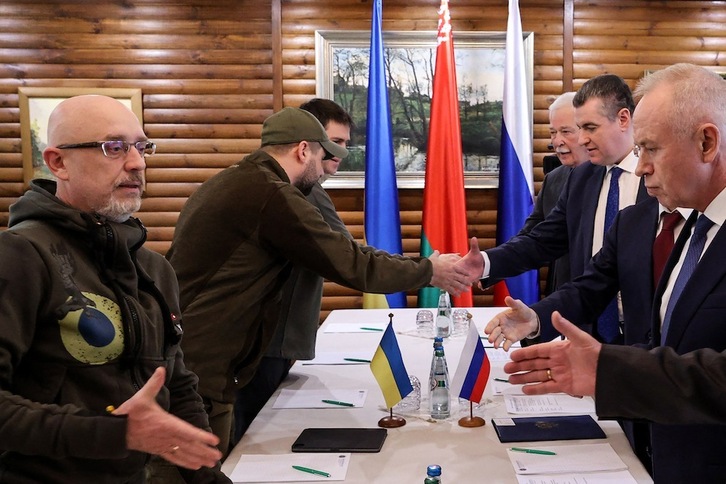 El ministro de Defensa de Ucrania, Oleksii Reznikov (izq.), estrecha la mano de los negociadores rusos antes de las conversaciones de este jueves, 3 de marzo, en la región bielorrusa de Brest.