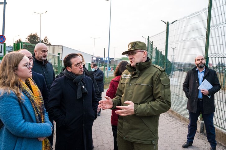Albares atiende las explicaciones de un guarda de fronteras polaco durante su visita al país. 