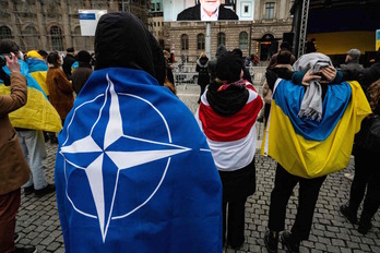 Manifestantes contra la guerra en Berlín, envueltos en las banderas de la OTAN, de Bielorrusia y de Ucrania. 