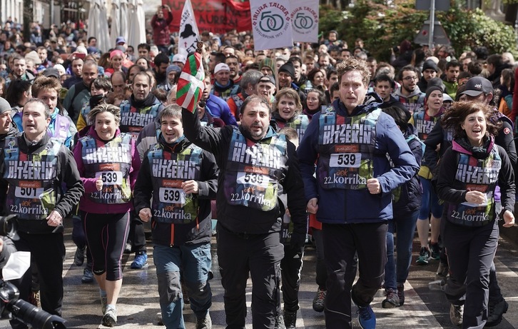 El presidente del Legislativo navarro, Unai Hualde, porta el testigo de la Korrika junto a varios parlamentarios.