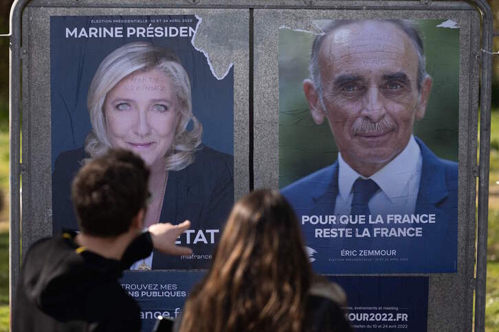 Bi pertsona, Marine Le Pen eta Eric Zemmourren kanpainako afixei begira.