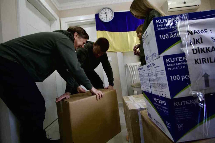 Yuri, a la izquierda, ayuda a empaquetar ayuda humanitaria que irá hacia Ucrania.