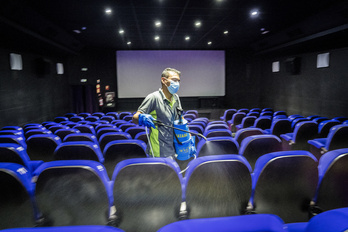 Un trabajador desinfecta una sala de cine en Donostia.