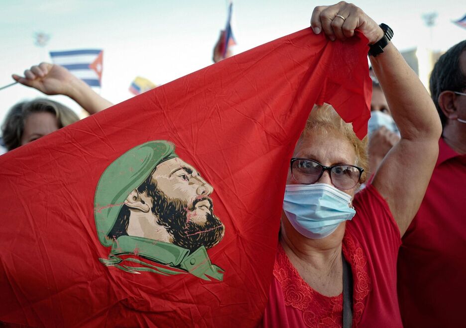 Emakume batek Fidel Castroren aurpegia duen bandera haizatu du Kuban.