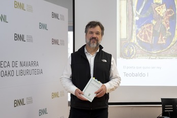 Xabier Irujo posa con su nuevo libro, con una imagen de época de Teobaldo I de Nafarroa.