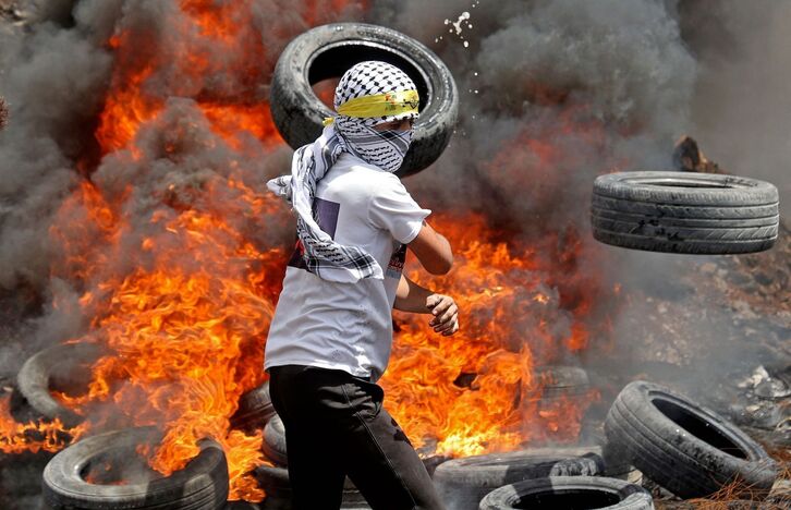 Un joven palestino en una barricada en la Cisjordania ocupada.