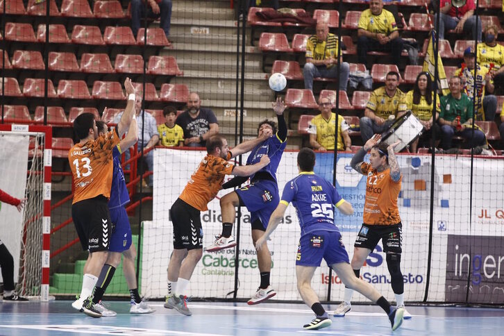 Rodrigo Salinas intenta ceder el balón a Azkue ante la defensa de Torrelavega.