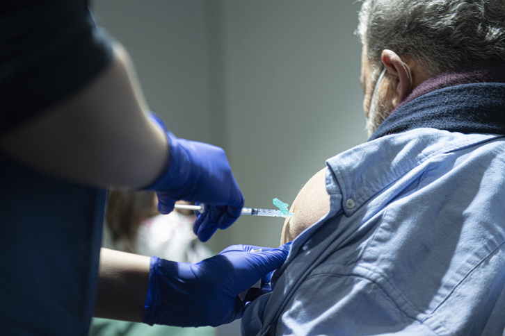 Un hombre recibe una vacuna contra el covid-19 en Iruñea.