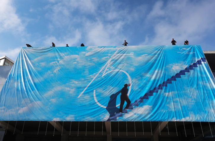 Operarios colocan el cartel oficial del certamen en La Croisette, este lunes.