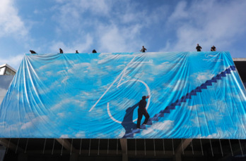 Operarios colocan el cartel oficial del certamen, este lunes.