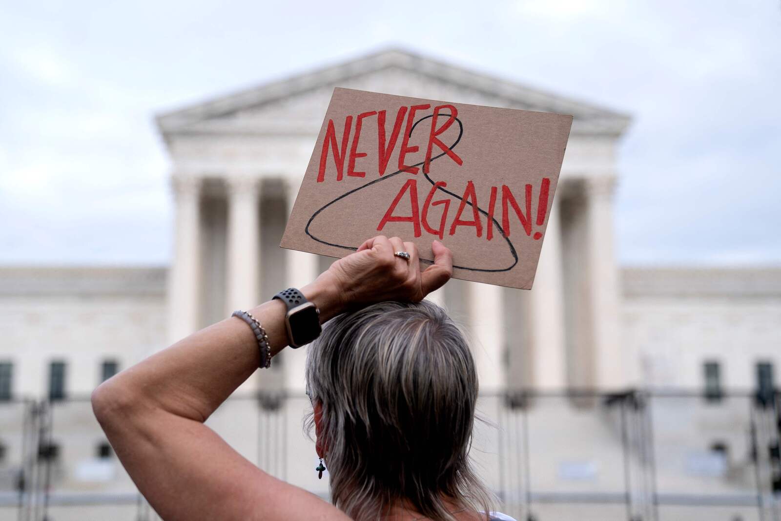 Una manifestante sostiene un cartel con las palabras &lsquo;Nunca M&aacute;s&rsquo; delante de la Corte Suprema de Estados Unidos en Washington. (Stefani REYNOLDS/AFP)