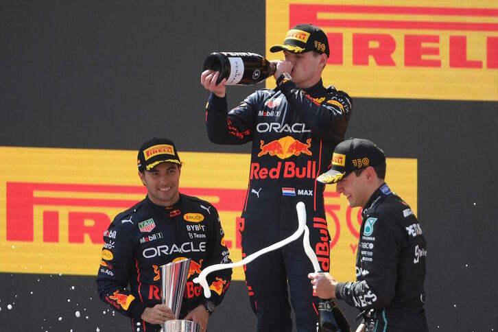 Verstappen bebe champán en el podio, donde Red Bull ha hecho doblete junto a Russell.