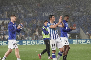 Varios jugadores de la Real se despiden de la afición bajo la lluvia de Donostia.