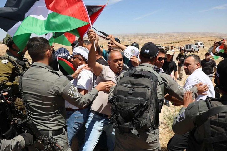 Soldados israelíes bloquean el paso a manifestantes palestinos.