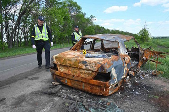 Policías ucranianos observan, en las inmediaciones de Jarkov, un coche dañado durante un ataque atribuido a los rusos.