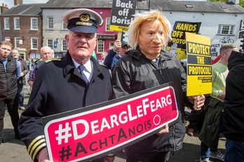 Participantes en una movilización en protesta por la visita de Borish Johnson al norte de Irlanda muestran un cartel en favor del gaélico.