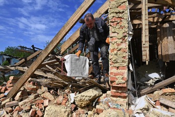 Un residente de Vilkhivka, cerca de Jarkov, saca sus pertenencias de una casa destruida por los bombardeos.
