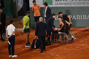 Alexander Zverev se retira en silla de ruedas ante la mirada de Rafa Nadal.