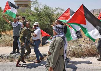 Palestinos ondean su bandera en la ciudad de Tuba, en una movilización para denunciar la expansión de las colonias israelíes en el valle del Jordán.