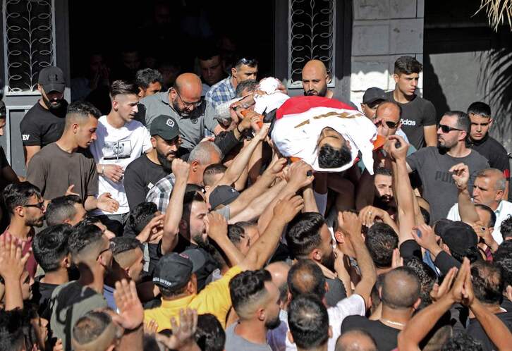 Decenas de personas trasladan el cuerpo sin vida del joven palestino.