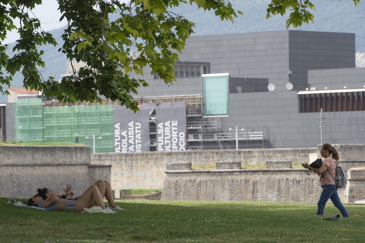 Dos personas se resguardan del calor en un parque de Iruñea.