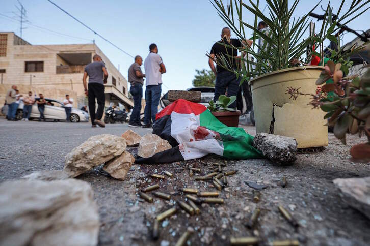 Casquillos de bala junto a una bandera palestina ensangrentada, en el lugar de los hechos. 