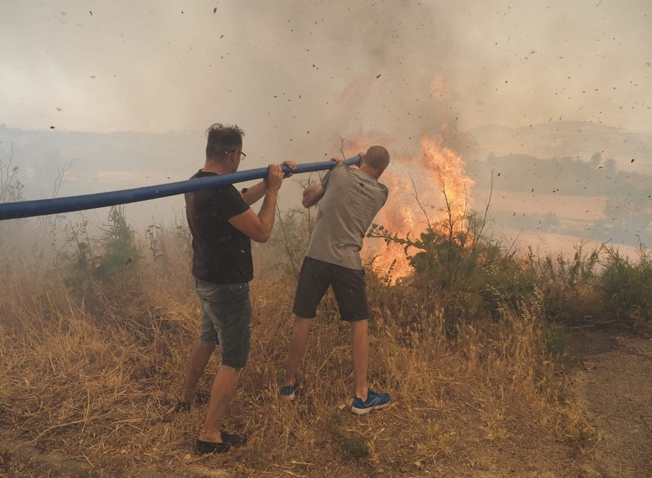 Vecinos de Obanos tratan de sofocar las llamas.