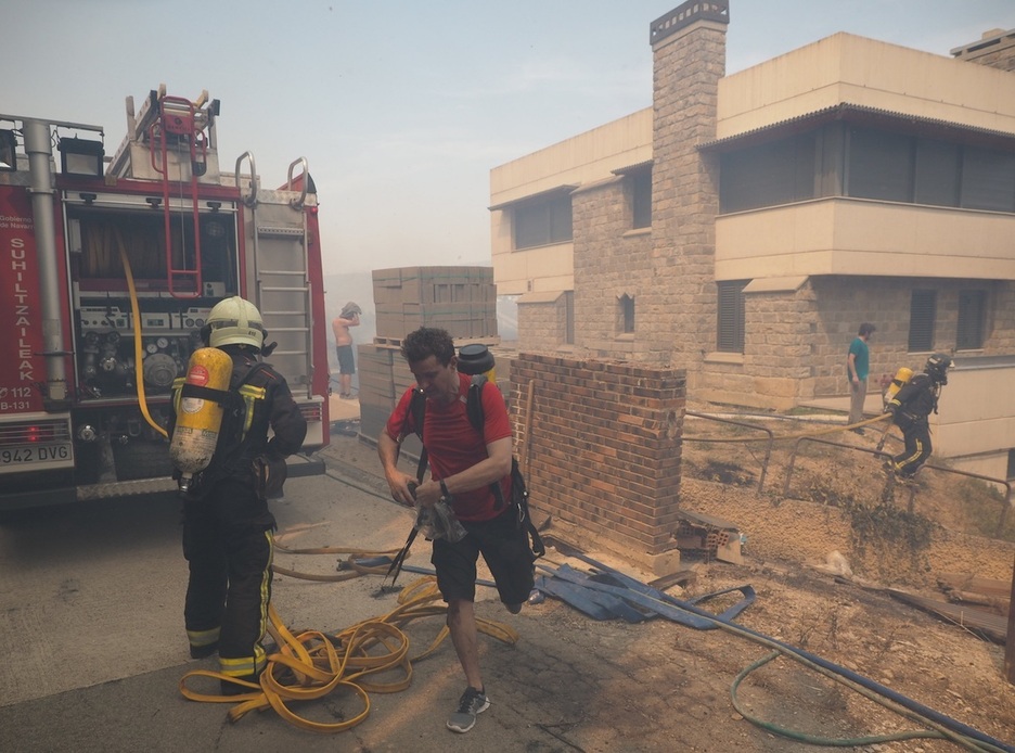 Efectivos de bomberos y vecinos trabajan en la extinción del fuego en Obanos.