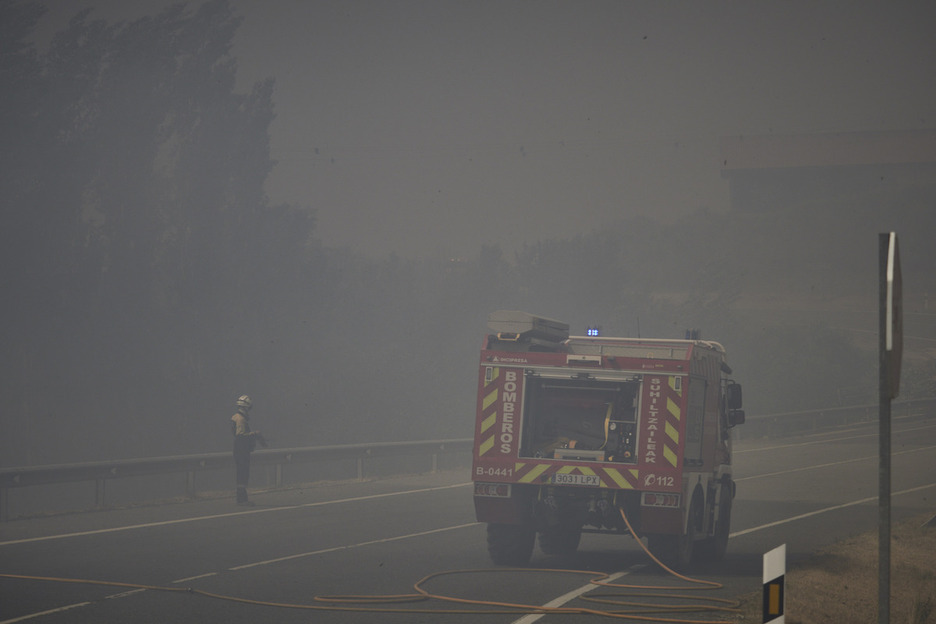 Un bombero envuelto por el humo durante la extinción de un incendio en Uxue.