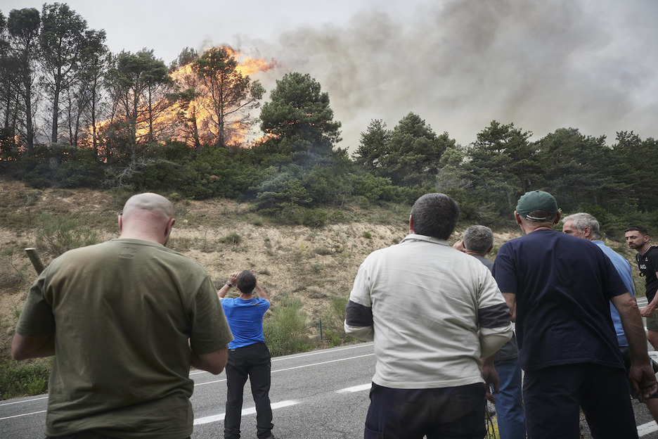 Unas personas observan cómo se queman los árboles en Erreniega.