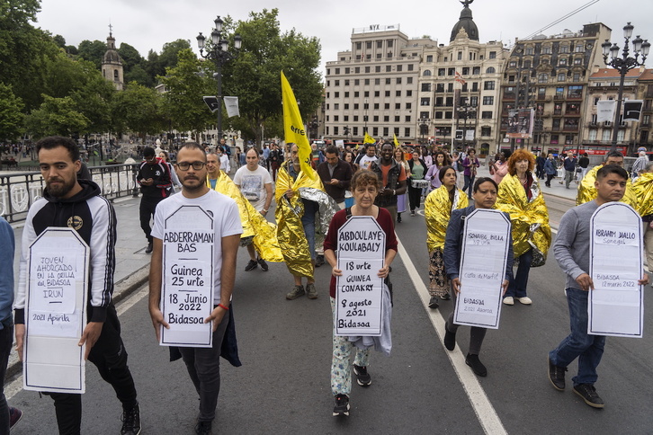 Un manifestante sujeta una lápida de cartón con el nombre de Abderrman Bas, último migrante fallecido en las aguas del Bidasoa.
