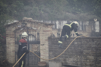 Un bombero salta una tapia en Gares, en las tareas de extinción del sábado.