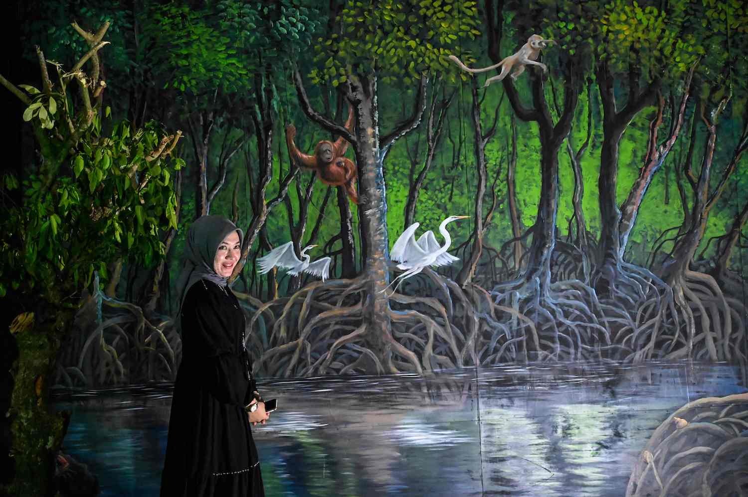 Un visitante posa ante una exposición sobre «El sentido del desastre del instinto animal» en un museo de Banda Aceh, Indonesia. (Chaideer MAHYUDDIN | AFP)