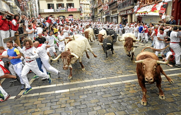 Una de las pancartas presentadas ayer, junto a sendas fotos de un txupinazo que se aguarda con especial emoción y del encierro.