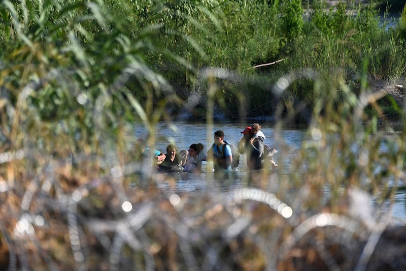 Un grupo que de personas cruza el río Grande. (Chandan KHANNA/AFP)