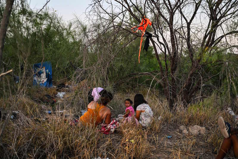 Una familia espera la llegada de la patrulla fronteriza tras haber sido interceptada. (Chandan KHANNA/AFP)